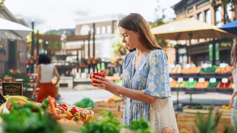 Woman Shopping for Fresh Vegetables from a Local Farm Market Stall.