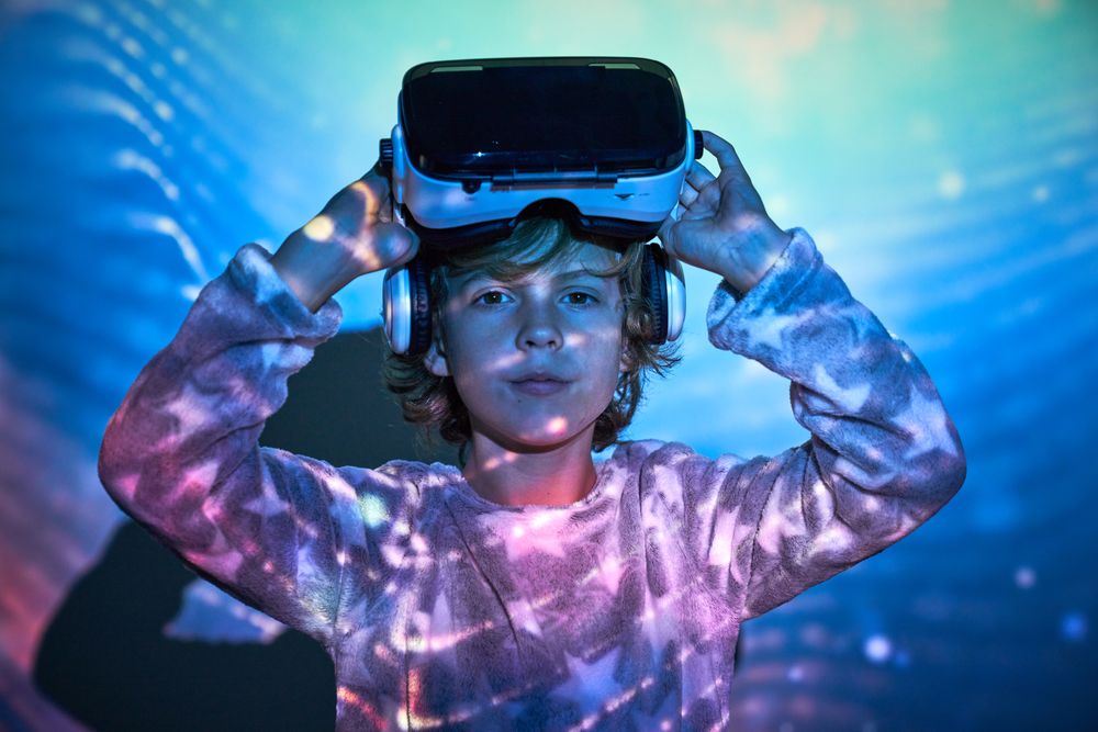 Adorable child taking off VR goggles and looking at camera again
