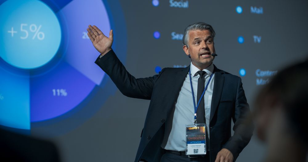 Successful Businessman Giving Presentation At International Business Forum.