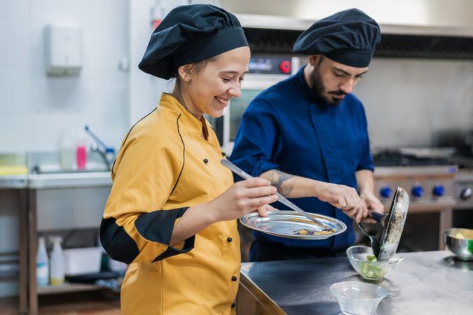 Professional chefs preparing dish in restaurant kitchen
