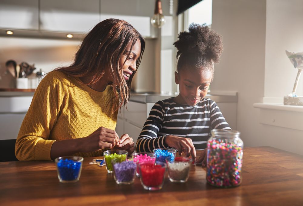 Mother and daughter working with beads at home