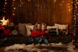 Siblings sitting in a room with christmas decoration