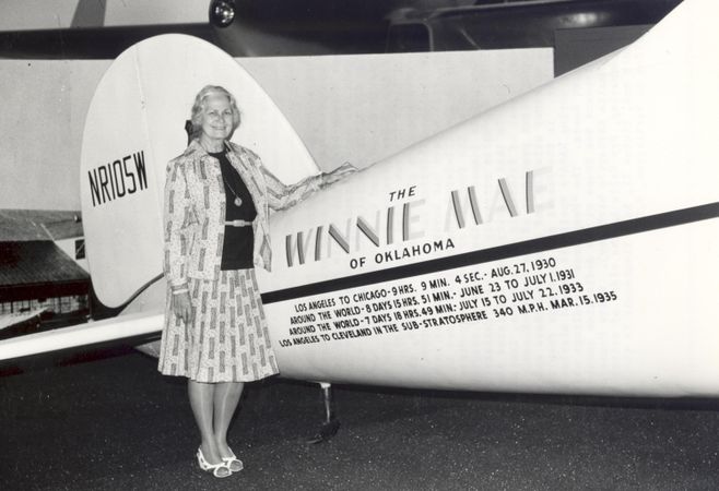 Aviator Fay Wells with the Winnie Mae Fay Gillis airplane