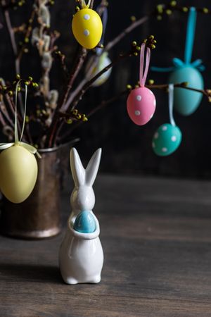 Branches in vase decorated with pastel egg with rabbit figuring