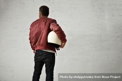 Rearshot of man in dark red leather jacket holding helmet in studio shoot 4NPA80