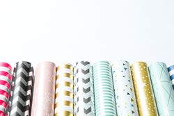 Rolls of festive wrapping paper on light background. Space for text