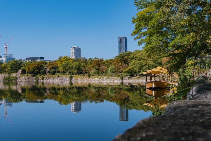 Still lake with board and skyscrapers in background