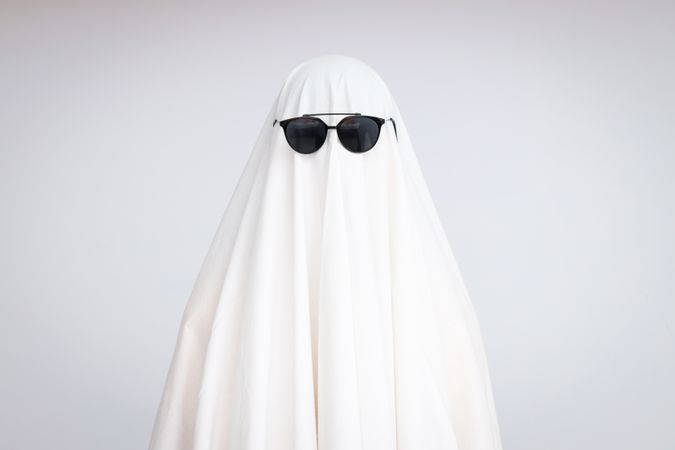 Concept of Halloween, Ghost with sunglasses on light background