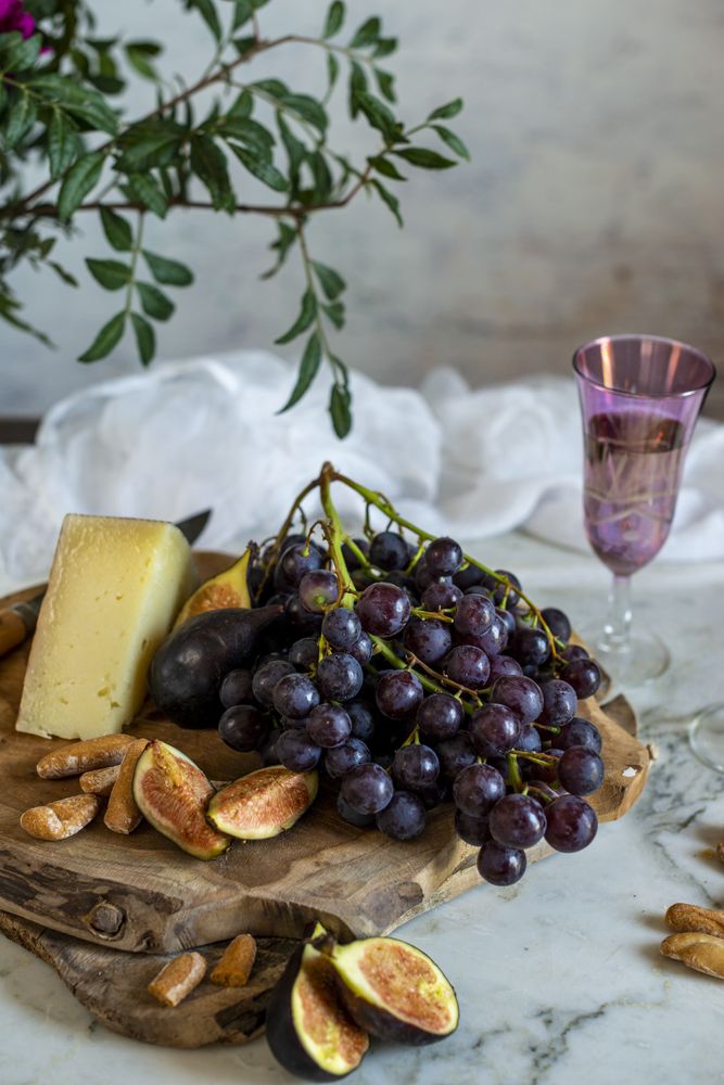 apes next to piece of cheese on cutting boards near pink flowers