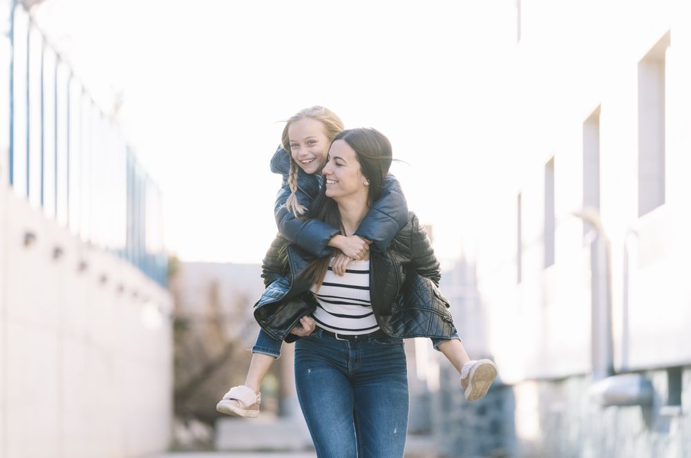 Woman doing young sister piggyback