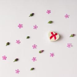 Heart shaped gift box with pink flowers and buds pattern on light background