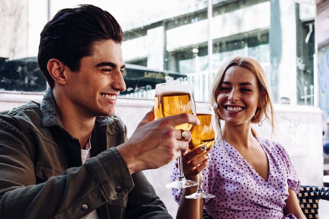 Happy young couple drinking beverages outdoors