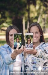 Women showing smartphones with their portraits 5lVP7o