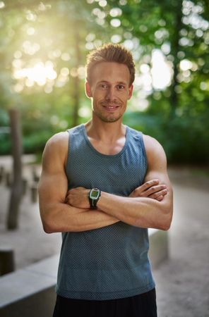 Portrait of man in sporty vest and smart watch with his arms crossed