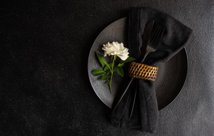 Minimalistic table setting with rose on plate