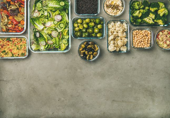 Variety of vegetable dishes arranged in glass containers, with copy space