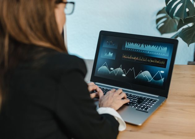 Female trader typing on laptop