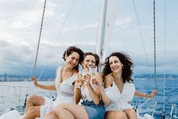 Cheerful friend with wine having fun on yacht