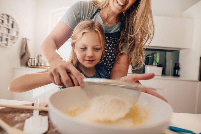 Cute girl making biscuits with her mother