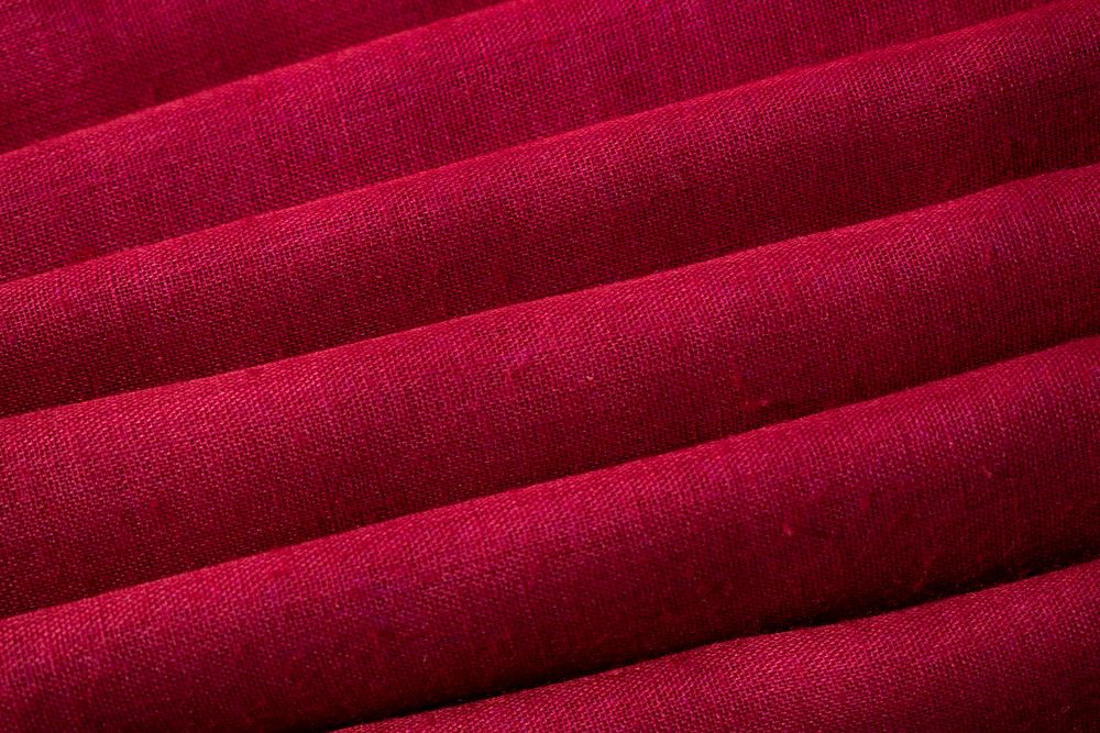 Close up Red fabric folded background texture.