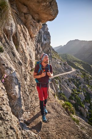 Male hiker walking along mountain path