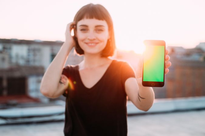 Woman smiling with smart phone outside