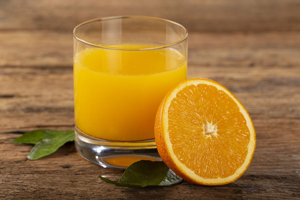 Glass with orange juice on the table.