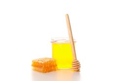 Glass jar, honeycomb and dipper isolated on blank background