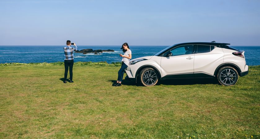 Couple traveling by car photographing the landscape