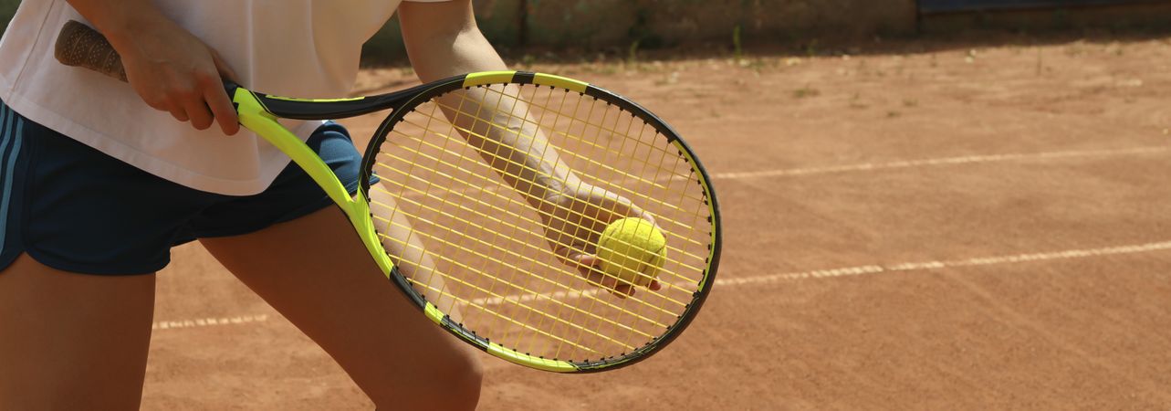 Woman hold racket and tennis ball on clay court