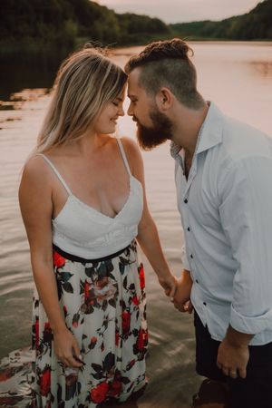 Loving couple standing ankle deep in water on beach