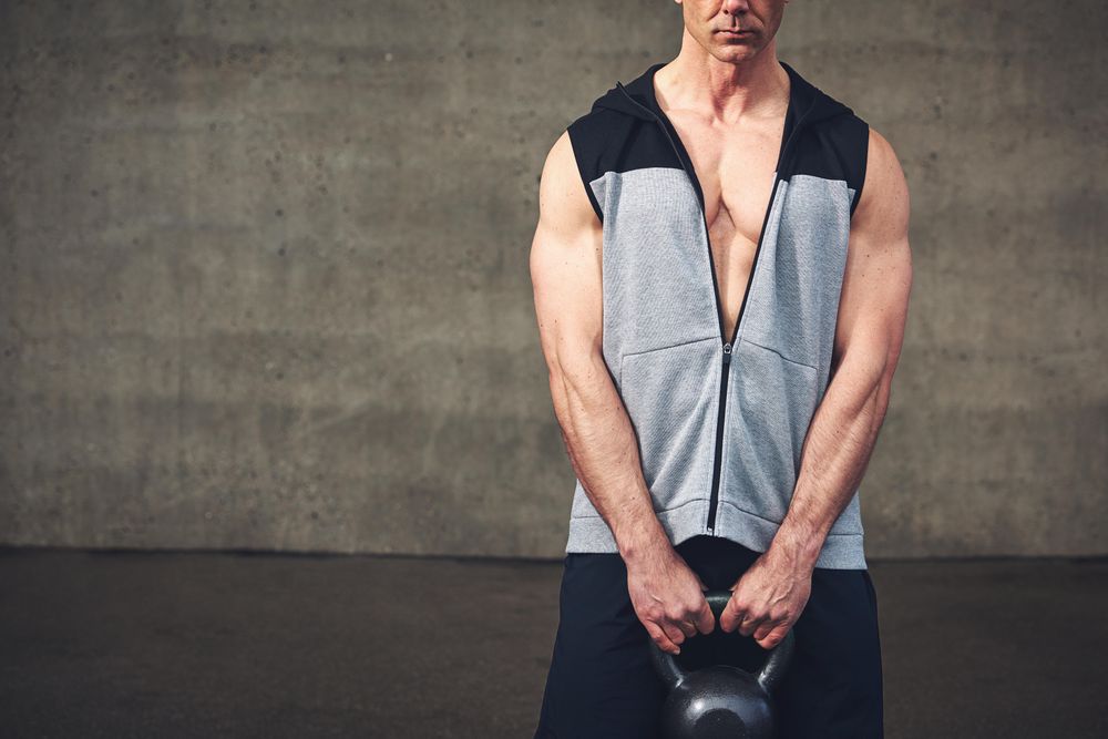 Man in vest holding kettlebell