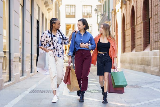Happy women walking down street on shopping trip