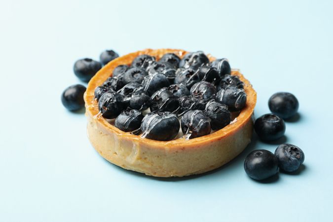 Blueberry pie on blue background, close up