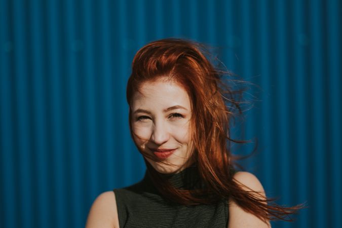 Smiling woman squinting in sun and enjoying weather