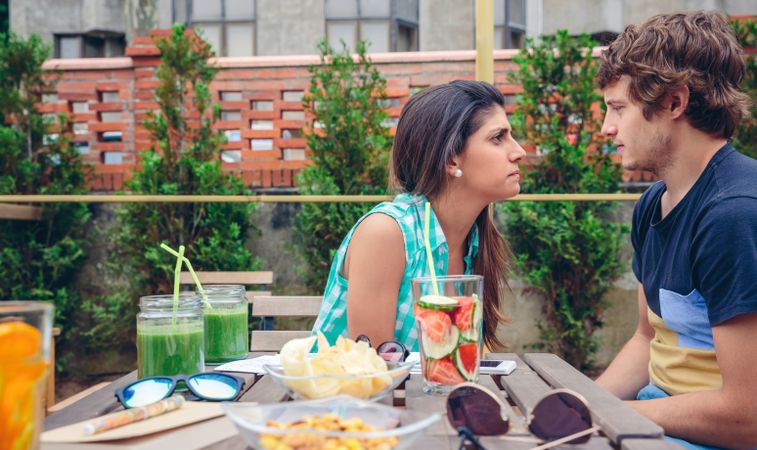 Young couple having argument at outside table