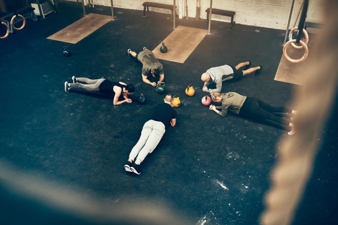 Group of people doing planks on gym floor