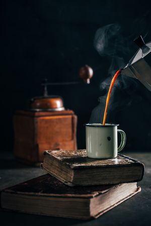 Pouring hot coffee in an enamel cup