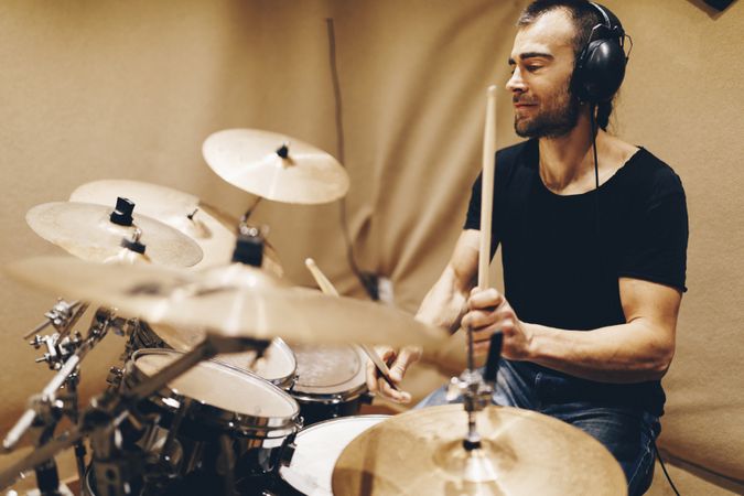 Man with headphones playing on drums