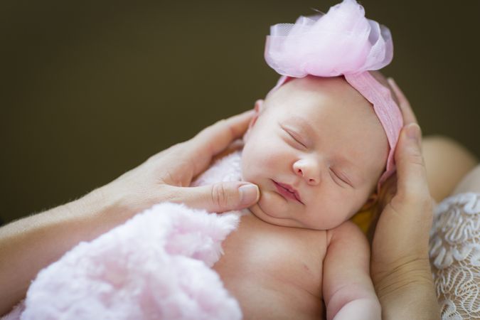 Hands of Parent Holding Her Newborn Baby Girl