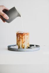 Man's hand pouring milk from pitcher to glass