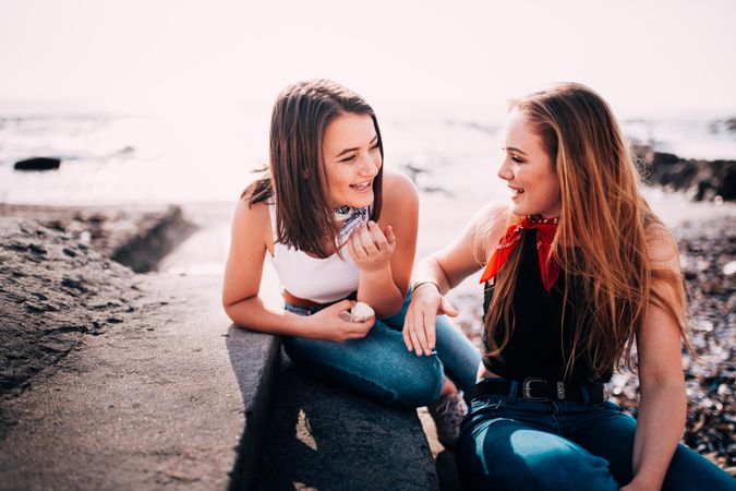 Two young women talking on the beach