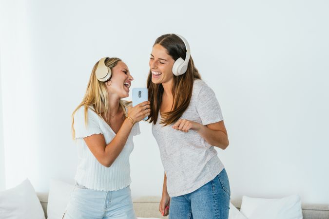 Cheerful women singing while listening to music