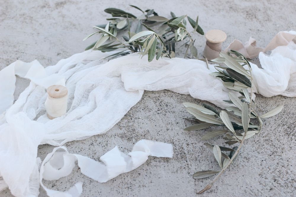 Olive tree branches, fruit with silk ribbons and muslin table runner