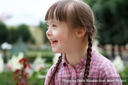 Laughing young girl with Down syndrome with her hair in braids 0gaWN4
