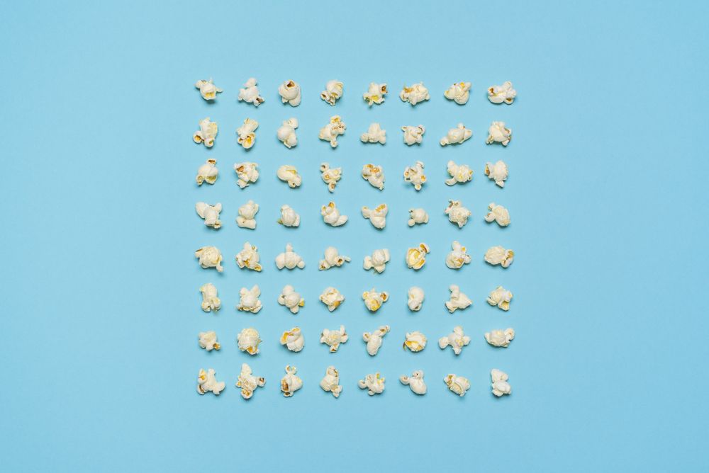 Popcorn flakes aligned symmetrically on a blue background