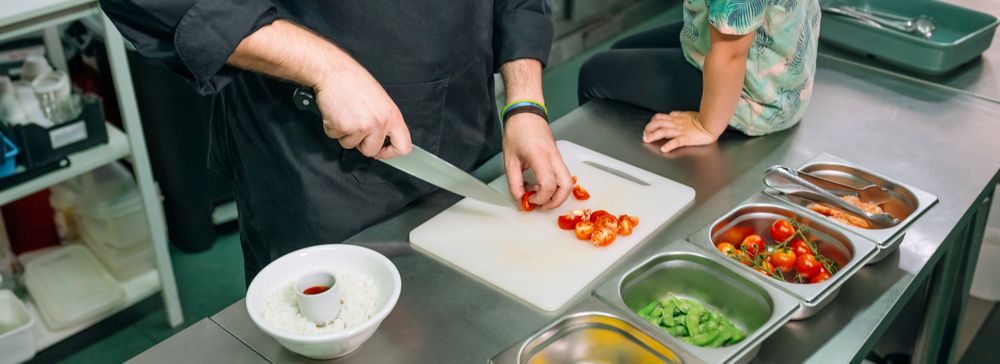 Banner of unrecognizable chef teaching little girl how to prepare poke bowl in professional kitchen