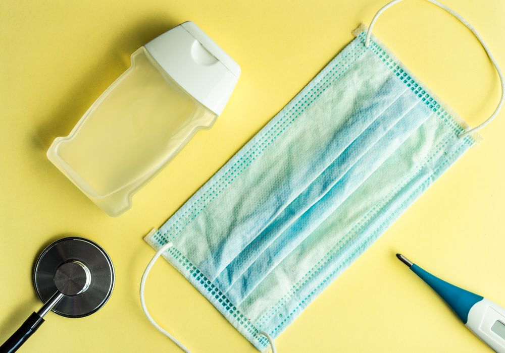 Top view of yellow table with soap, digital thermometer and cotton
