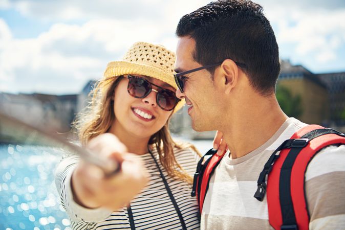 Cute smiling couple taking photo with selfie stick