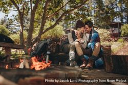 Couple in love sitting near a bonfire 5wX3P9
